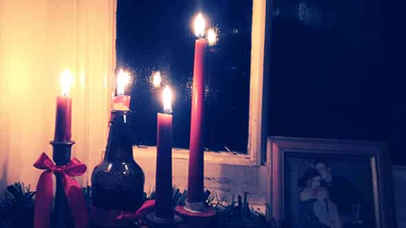 Four lit advent candles in the windowsil.